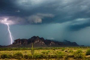 A lightning storm threatens a desert landscape.
