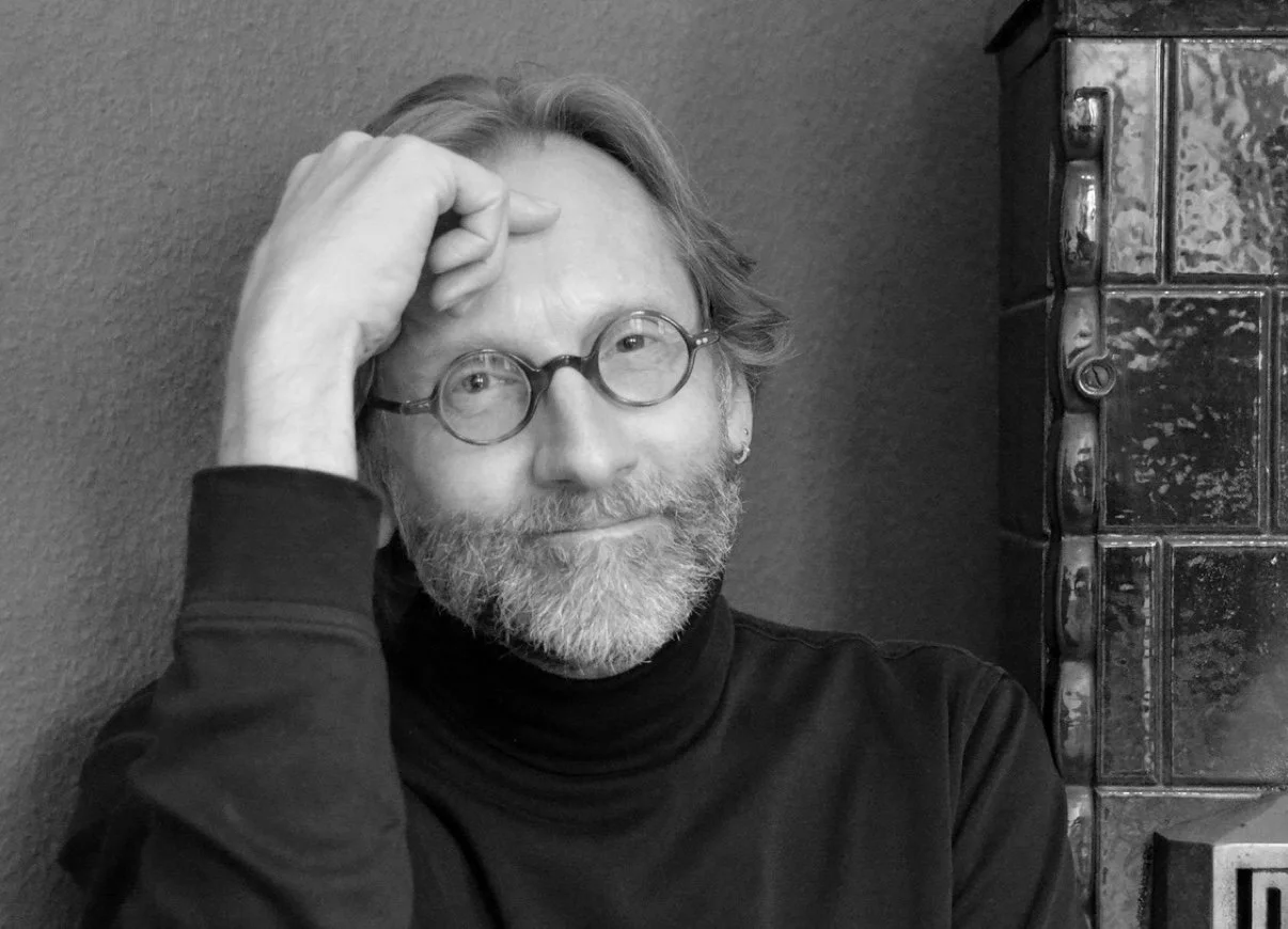 Lance Olsen with round glasses, smiling.