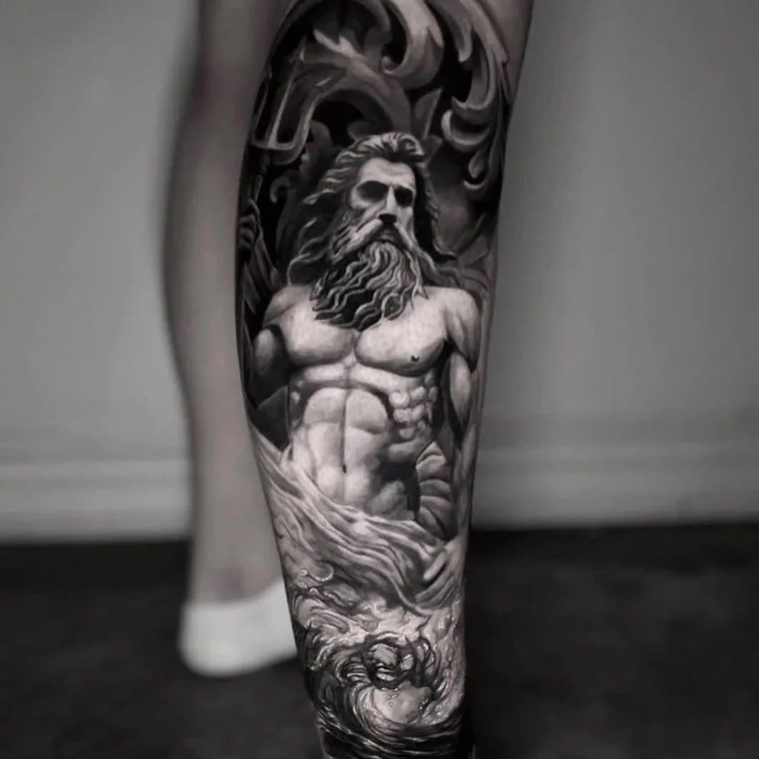 Black and gray tattoo of a muscular bearded man with long hair, emerging from swirling waves, covering the lower leg.