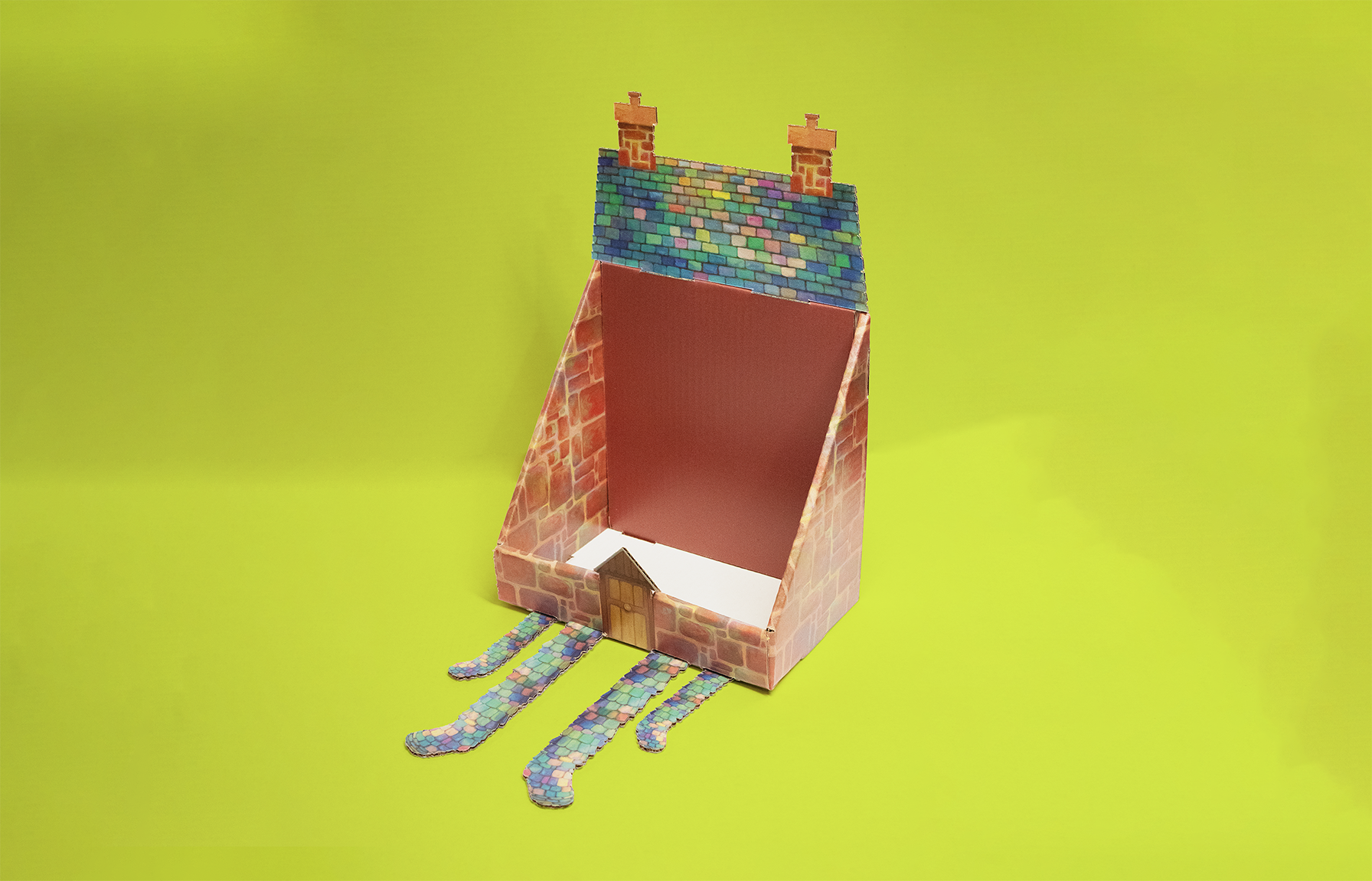 A paper craft model of a house with tentacle-like appendages on a bright yellow background.