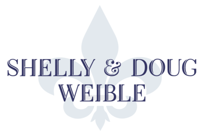 Text reading 'Shelly & Doug Weible' with a stylized blue fleur-de-lis in the background.