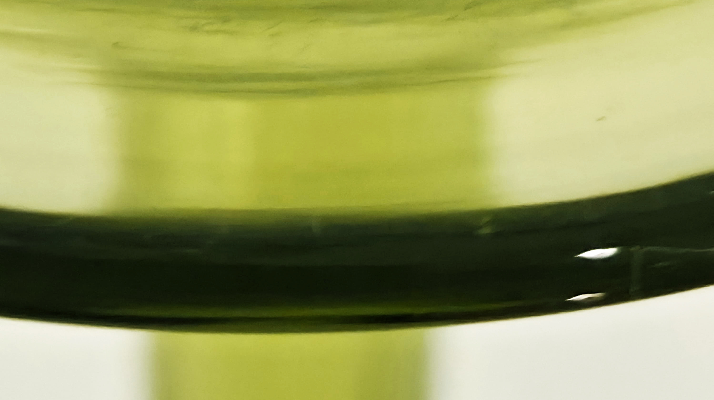 Close-up of a green and black object or surface with reflections and shadows, possibly a metallic or plastic item.