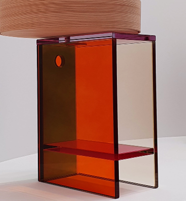 Colorful glass display cabinet with orange, purple, and clear sections, topped with a wooden round tray.