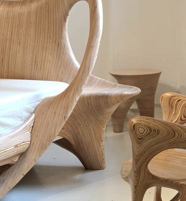 Wooden bed frame and matching wooden furniture in a minimalistic bedroom.