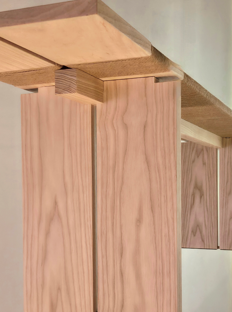Close-up of wooden furniture showing vertical wooden panels and a horizontal tabletop with precise joinery.