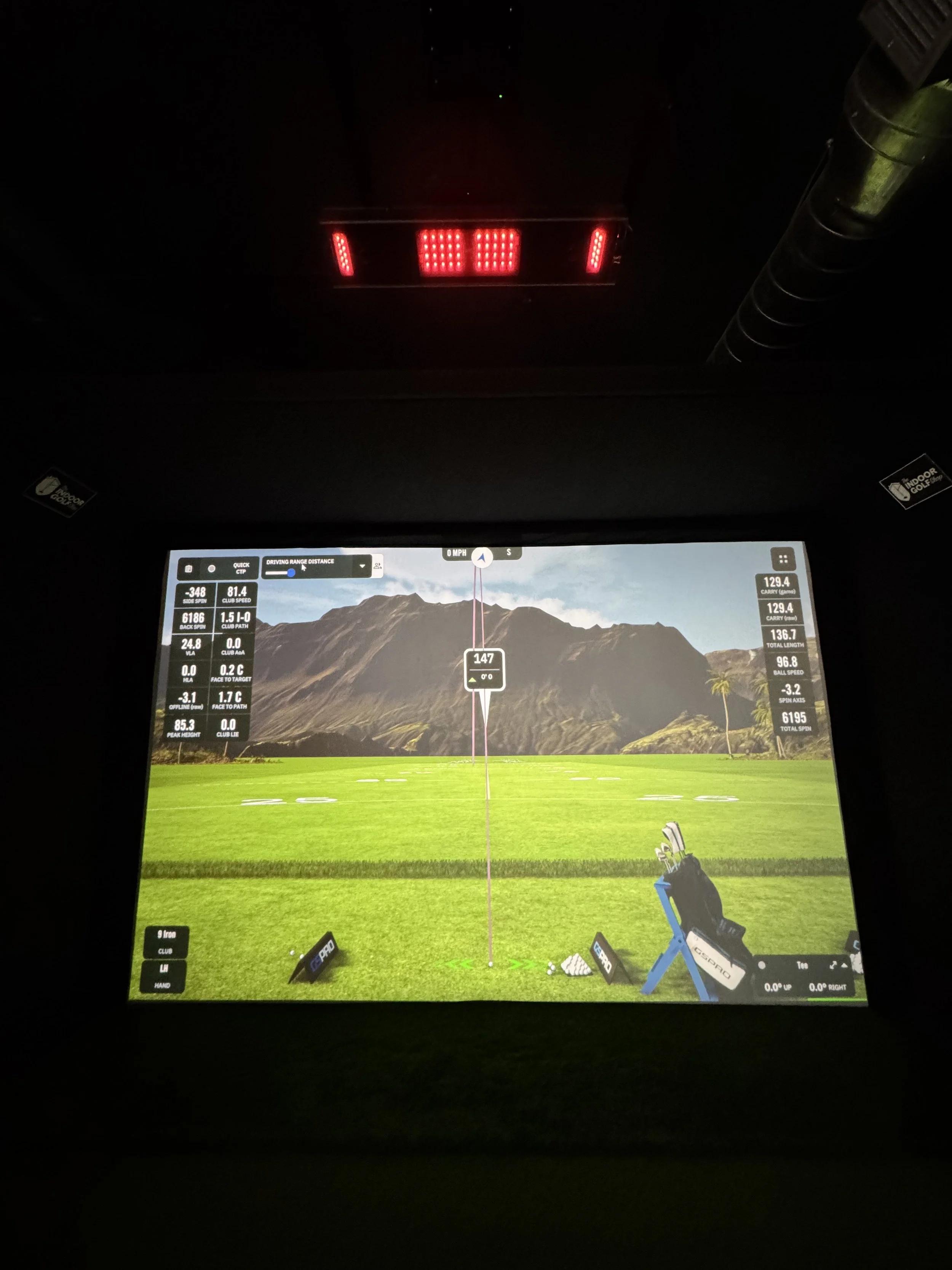 The Uneekor Eye XO launch monitor tracks a golf shot from above while real-time ball flight and swing data are displayed on the GSPro simulator screen.