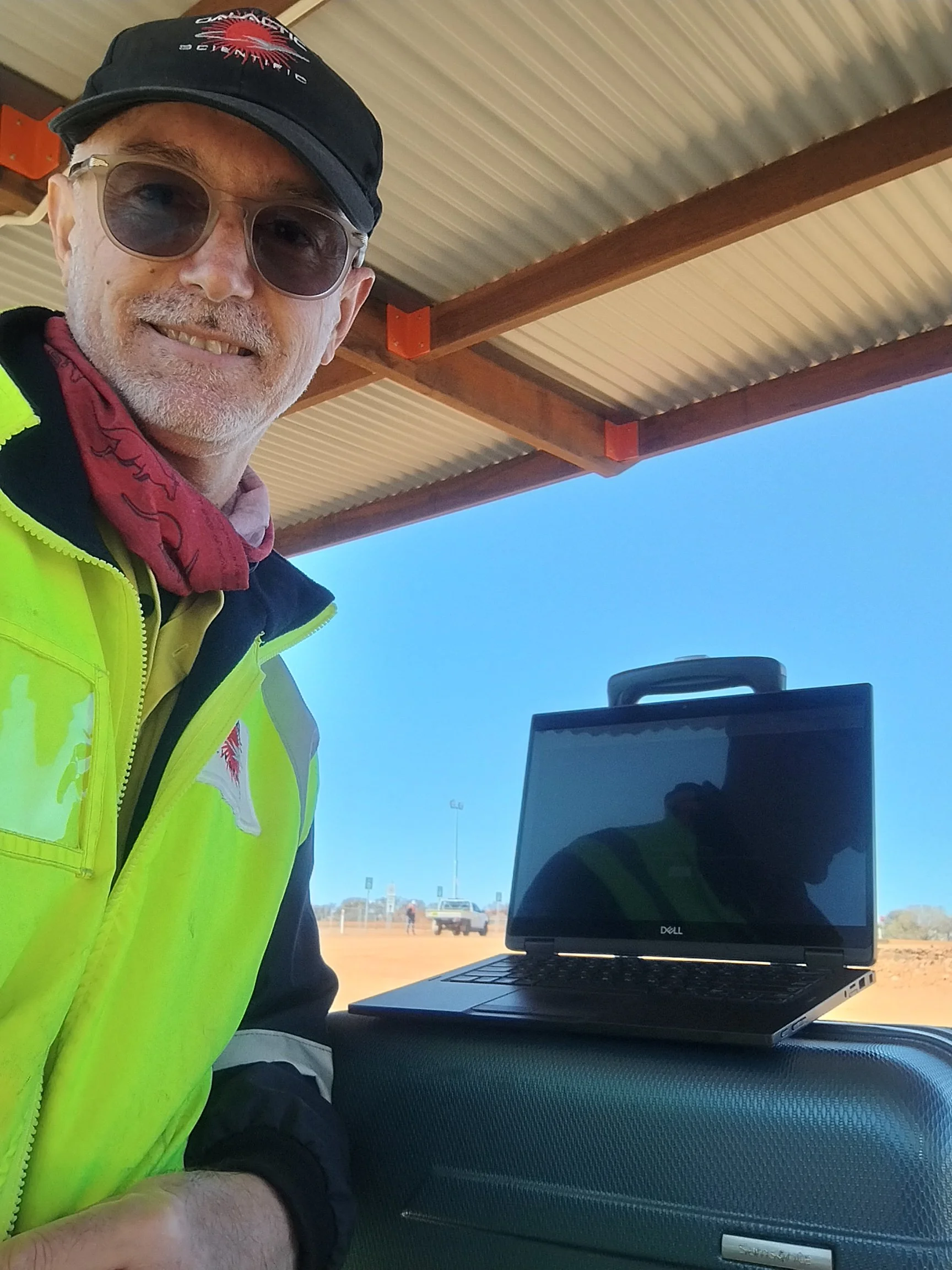 Man standing at laptop outside