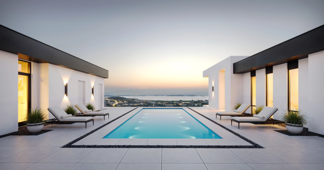 Luxury rooftop pool area with white lounge chairs and potted plants, overlooking a city and water at sunset.