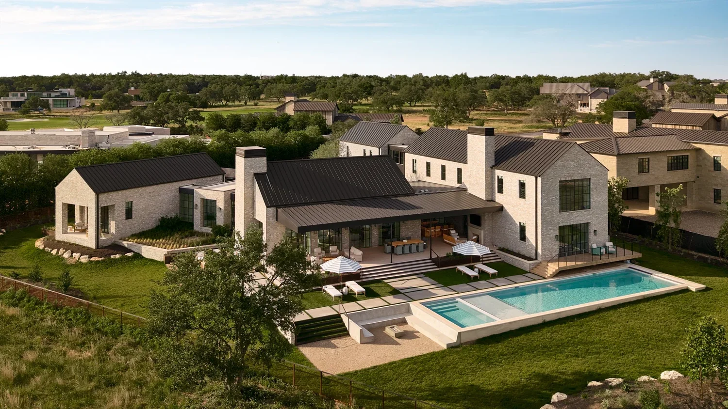 Modern house with a backyard swimming pool and patio, surrounded by greenery and neighboring houses.