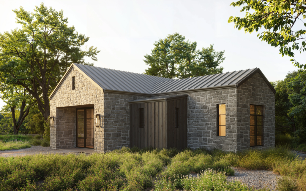 A modern house made of gray stone with a metal roof, surrounded by greenery and trees under a bright sky.