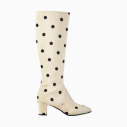 Cream-colored knee-high boots with black polka dots and a low block heel.
