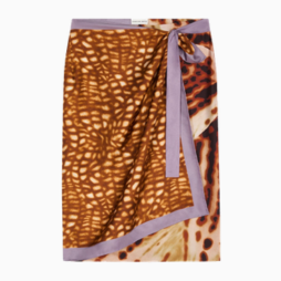 Close-up of a patterned fabric swatch with an orange and brown animal print and a purple border.