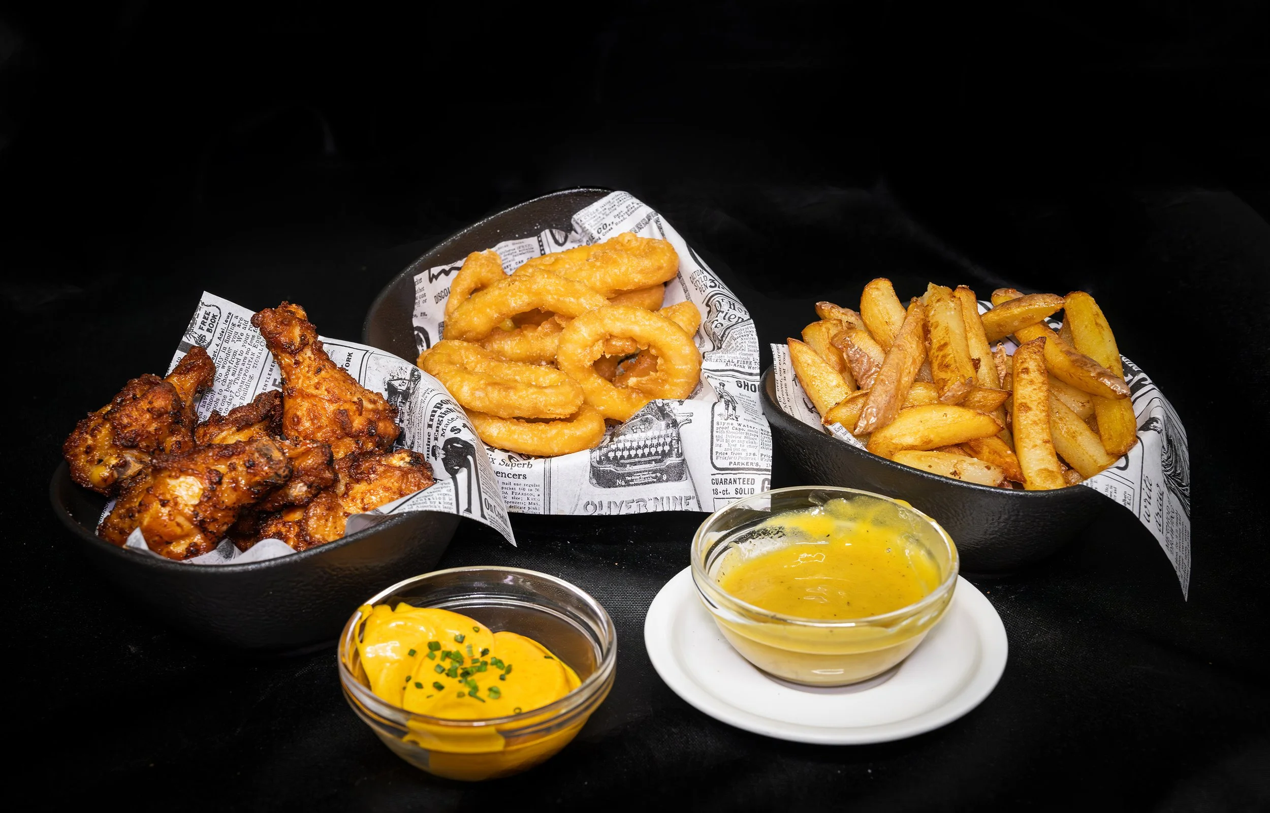Aletes de pollastre, calamars i patates fregides