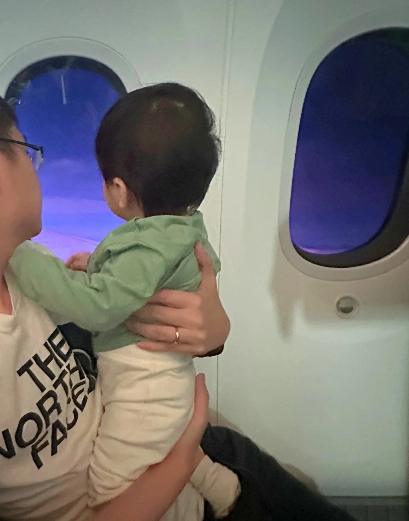 Baby looking out aeroplane window, flight home on ANA airlines