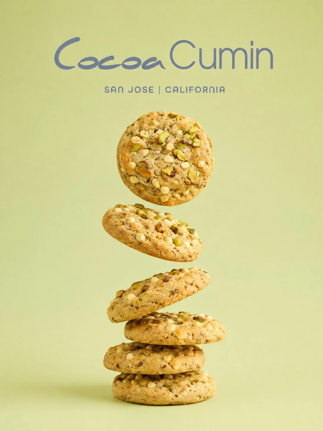 Stacked cookies with chopped nuts and green pistachios on a light green background, with text 'CocoaCumin San Jose California' at the top.