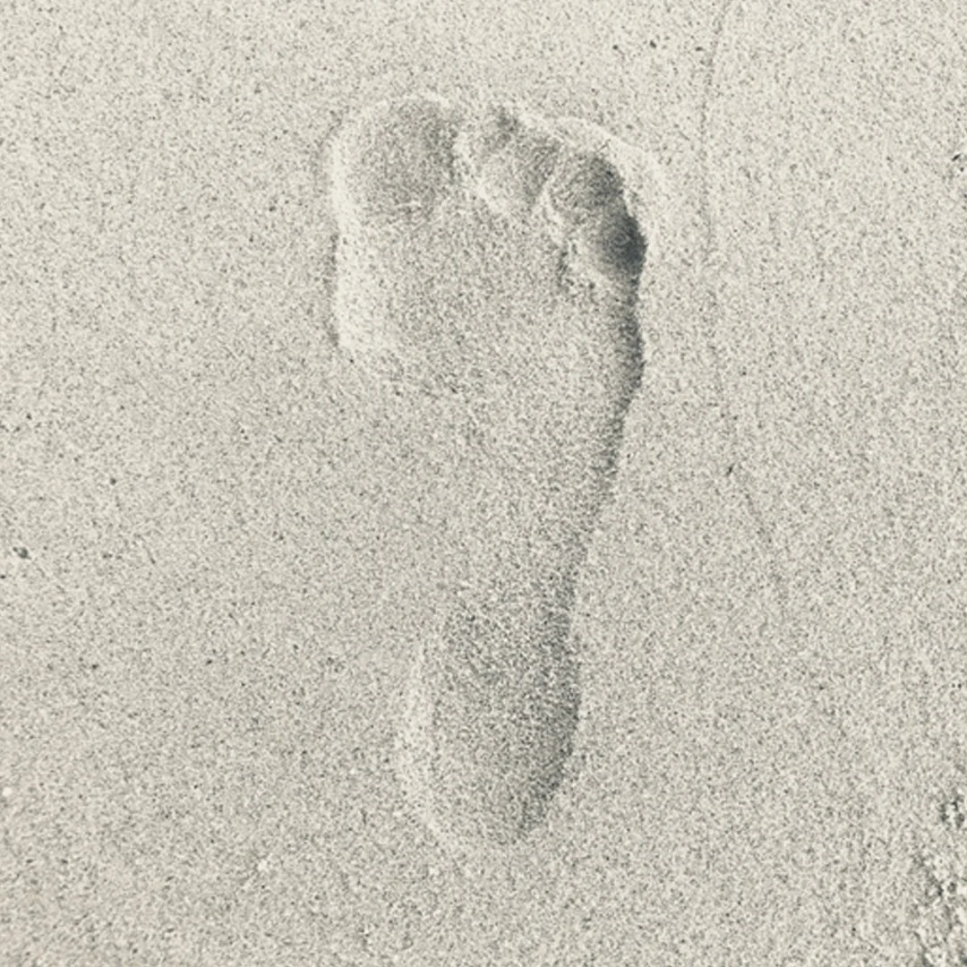 Single footprint in light-colored sand.