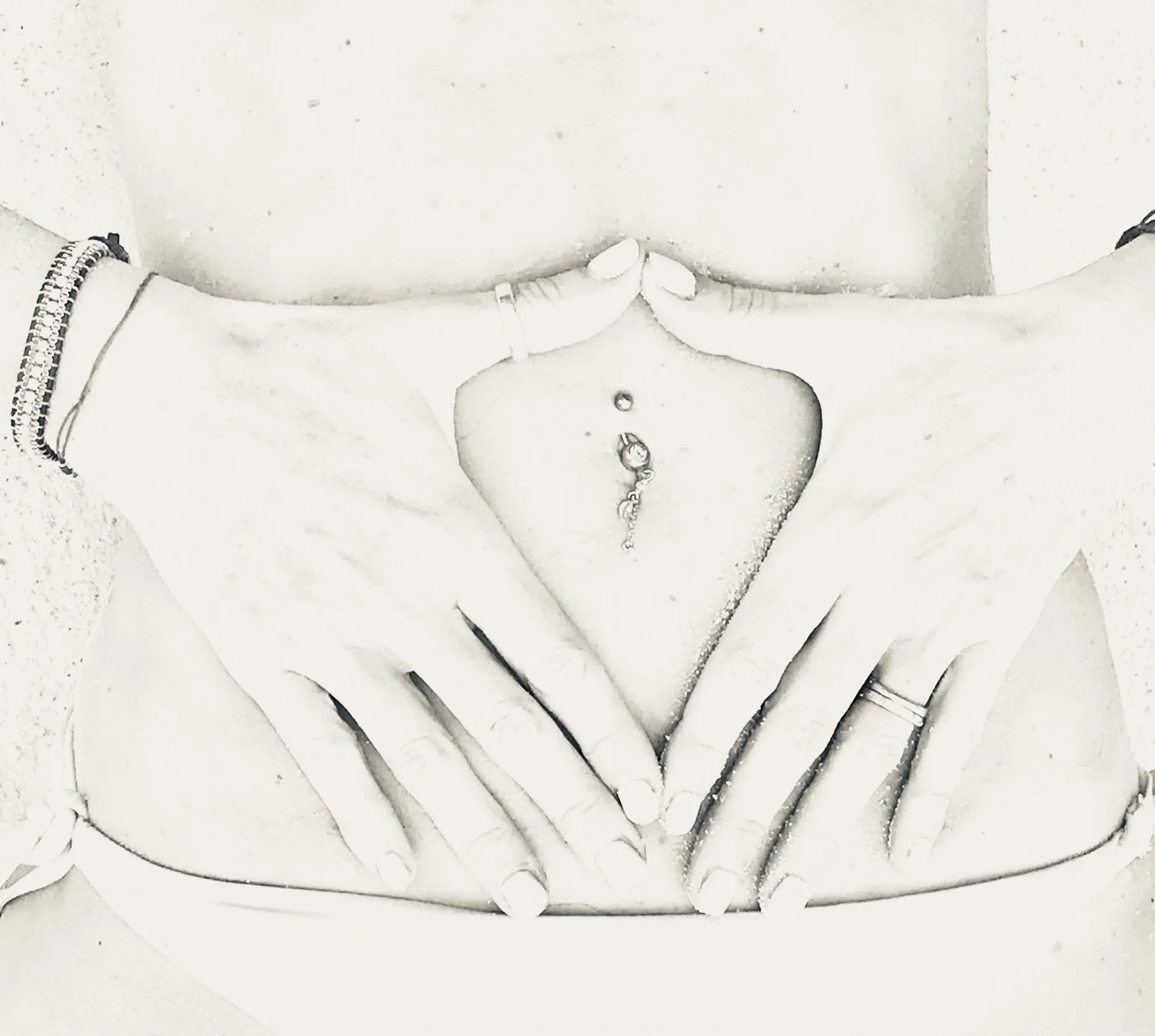 Close-up black and white photo of a person's torso and hands, with jewelry and wristbands, and a belly button piercing.