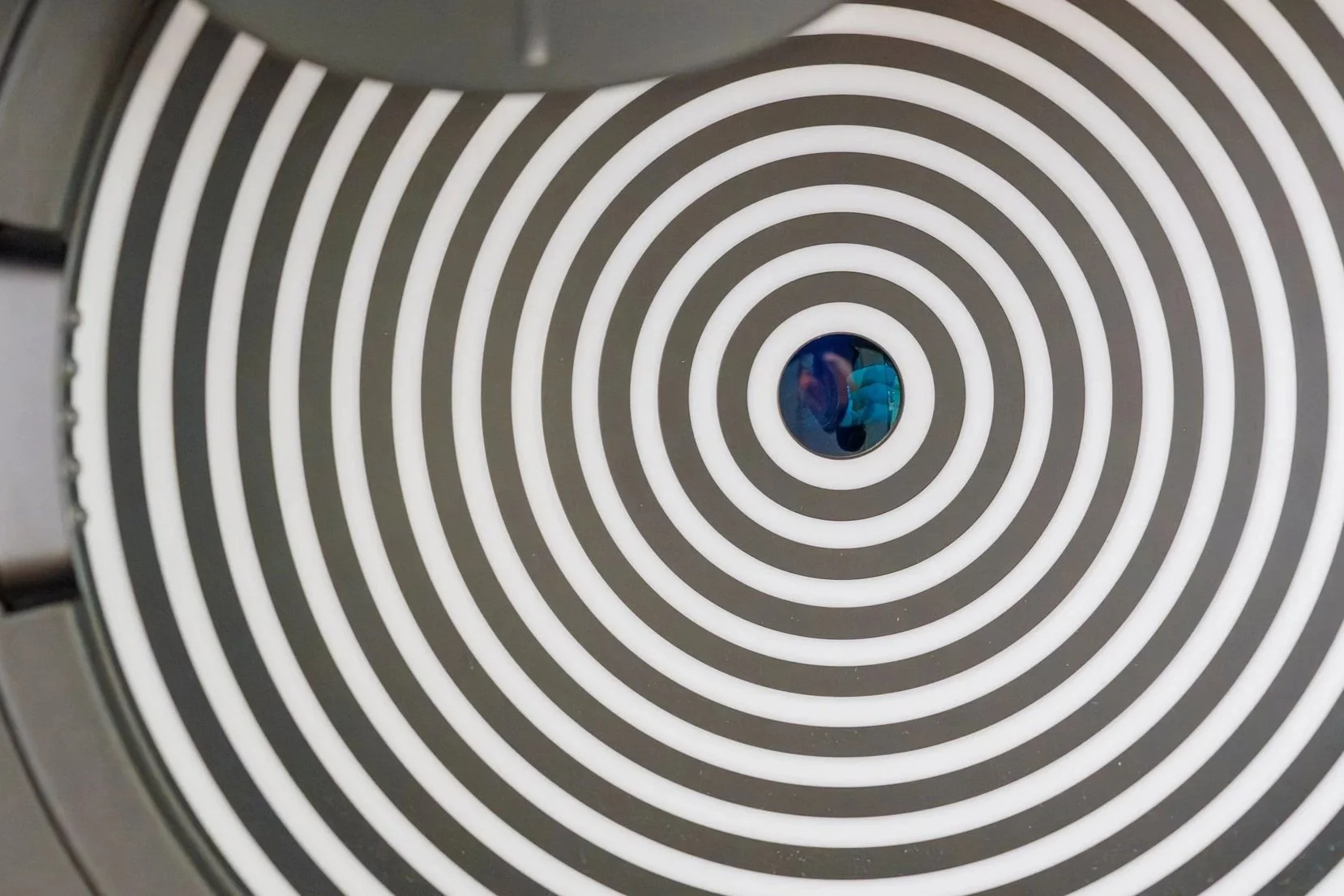 Nahaufnahme eines Rauchmelders mit spiralförmigen Belüftungsschlitzen, Blick nach oben
