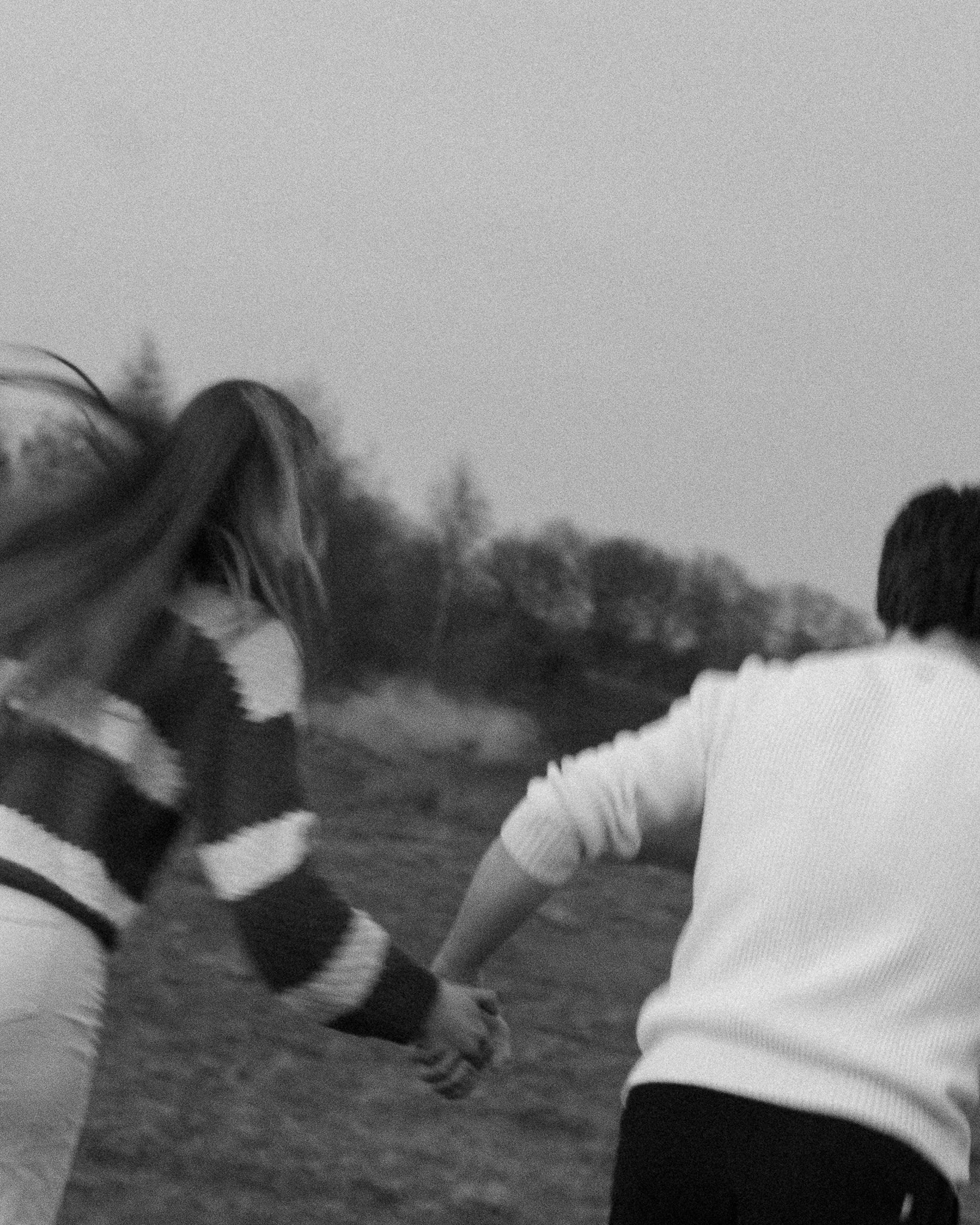 Twee mensen die hand in hand wandelen op een pad, mogelijk in een park of bos, in zwart-wit