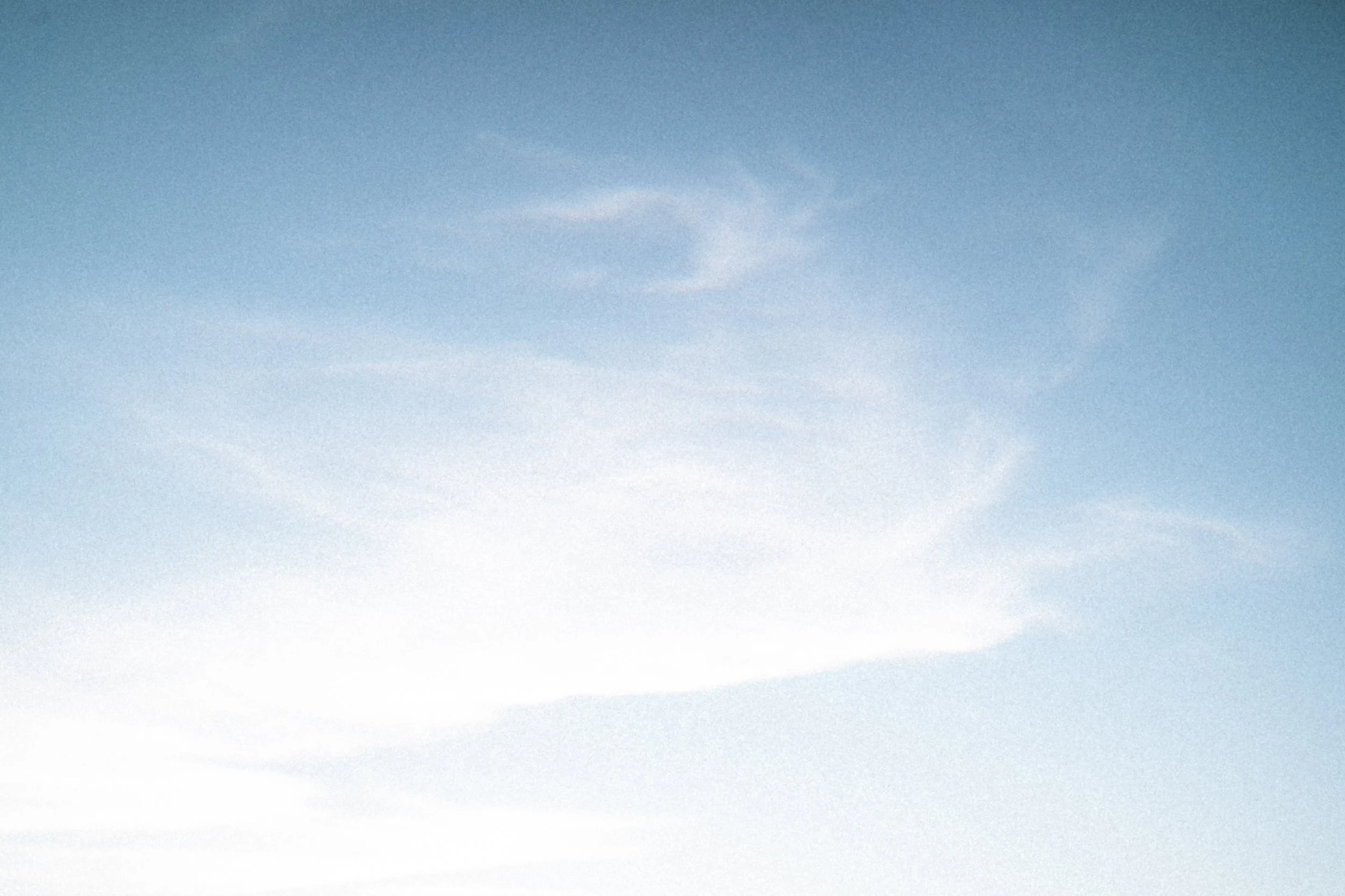 De lucht met enkele witte wolken.