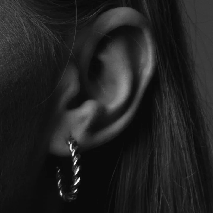 Close-up of a person's ear with a hoop earring.