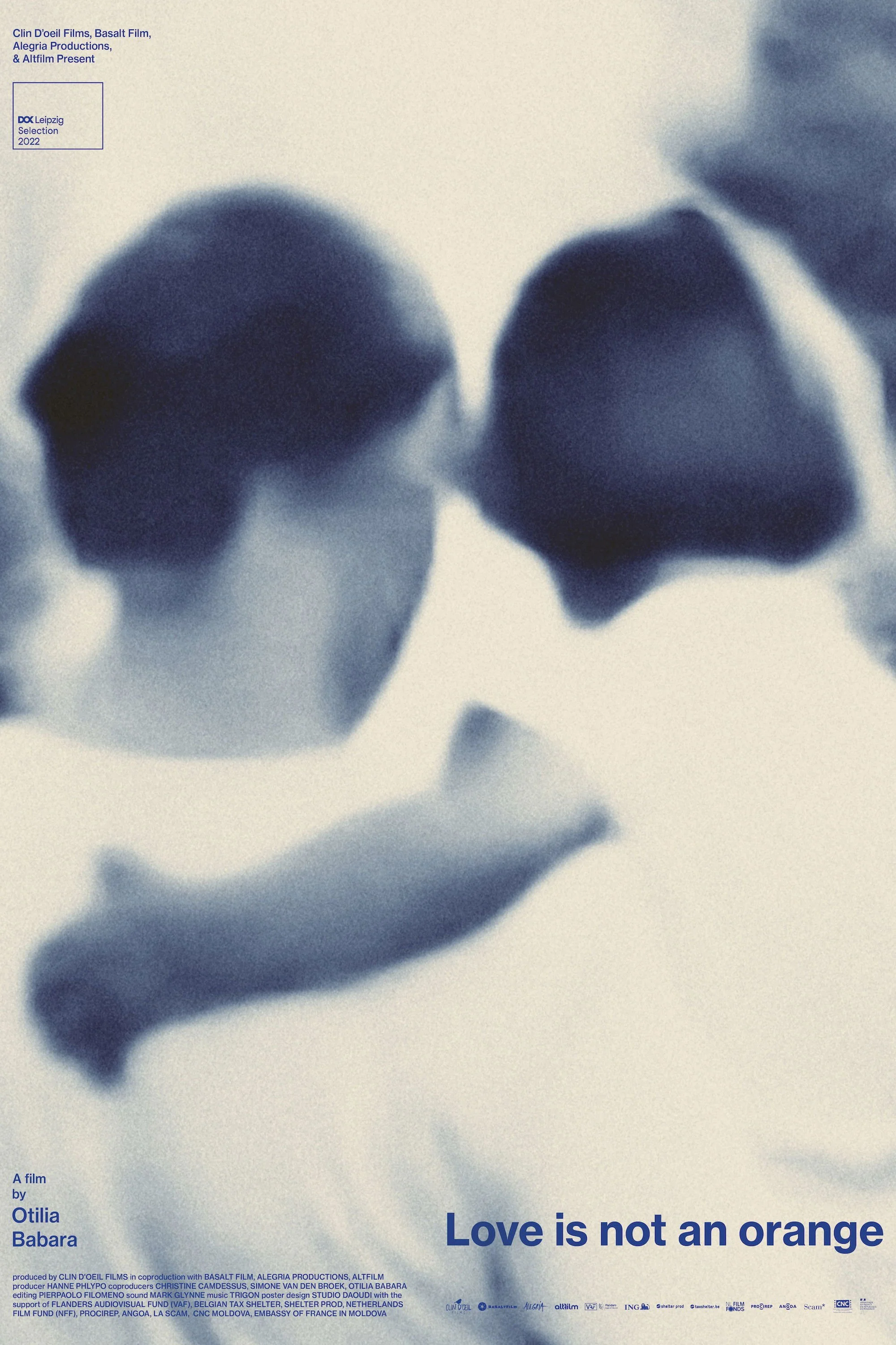 Close-up black-and-white image of two heads, possibly of women, with hair covering parts of their faces, with text about a film titled 'Love is not an orange' and information about film production and credits.