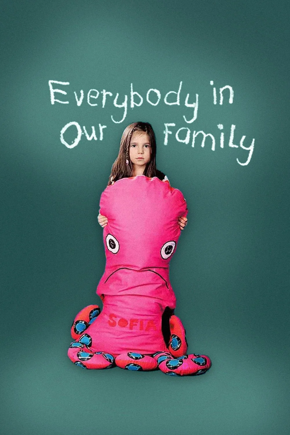 A girl holding a pink octopus-shaped pillow with the name Sofía on it, standing in front of a green background with white handwritten text that says, "Everybody in Our Family."