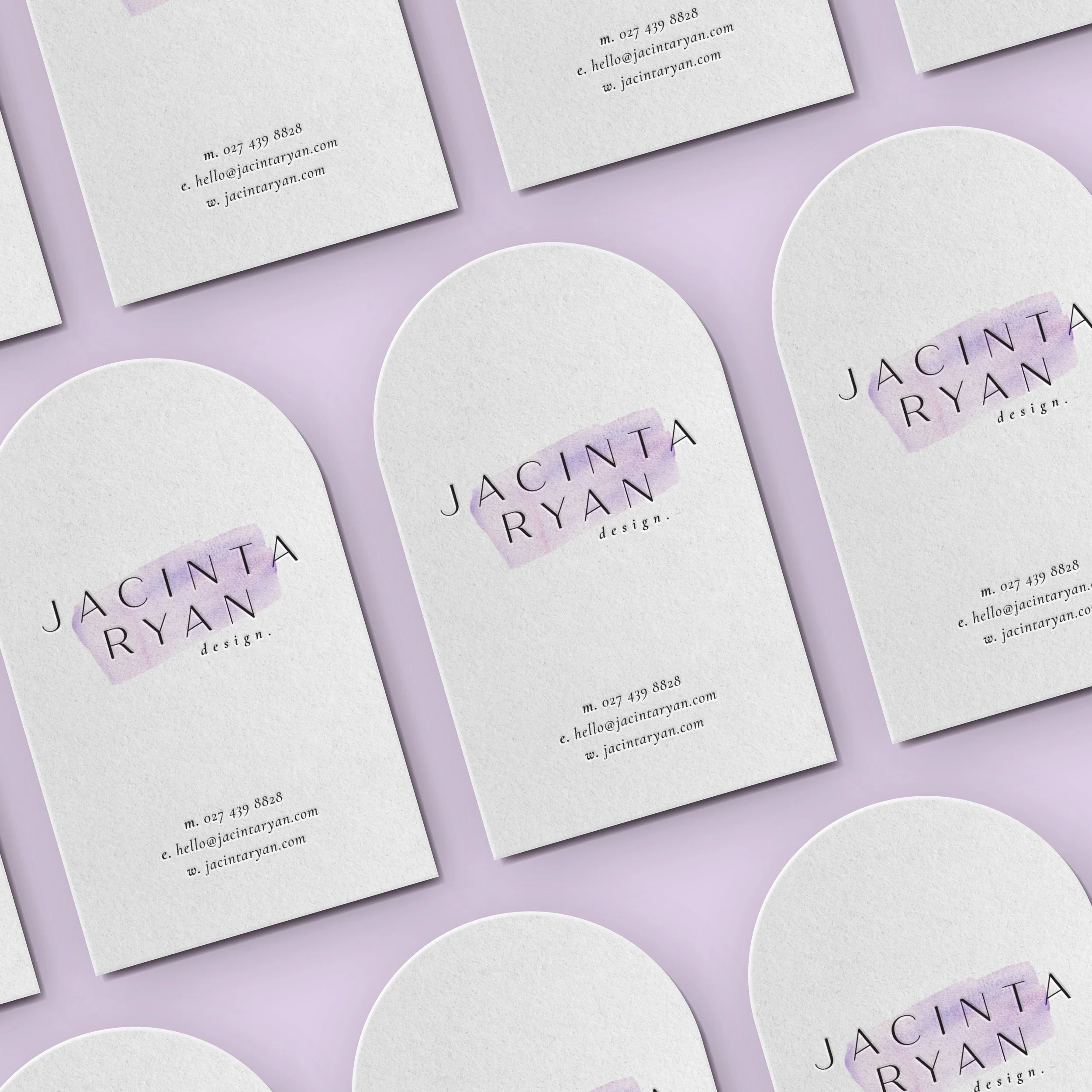 Business cards and rounded cards with the logo 'JACINTA RYAN design' and contact details on a lilac background.