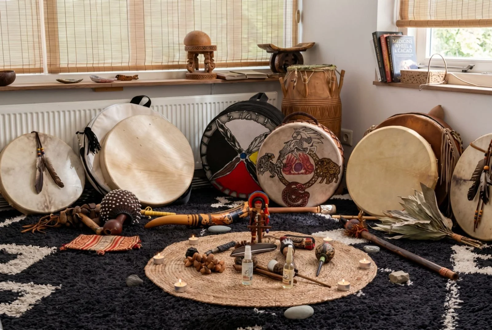 Traditional indigenous sound healing instruments including shamanic frame drums, rattles, and ceremonial pipes arranged for a sacred frequency journey at KAIRÉ