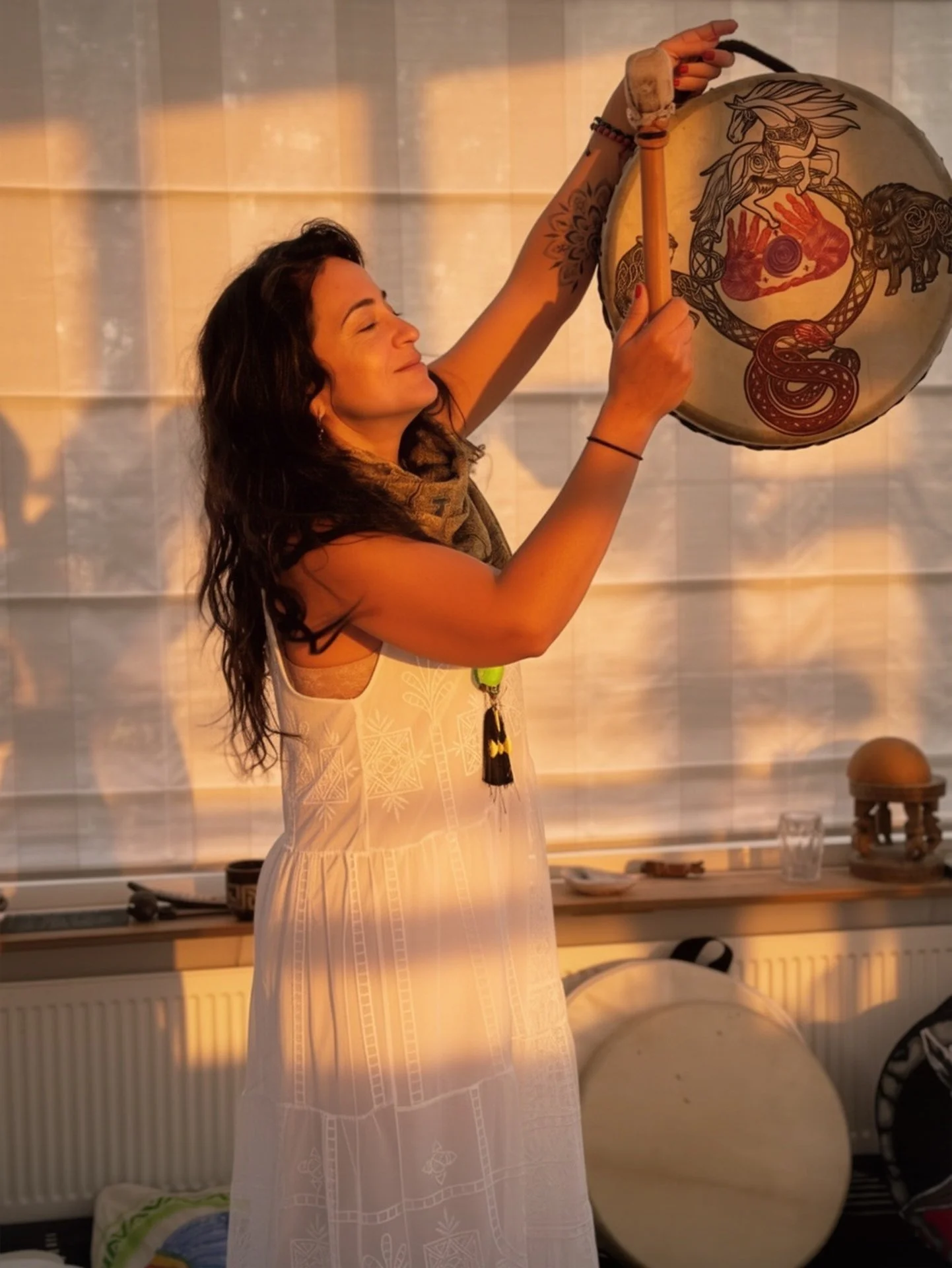 MadaLis holding a shamanic hand drum for ancestral rituals and sound healing at KAIRÉ
