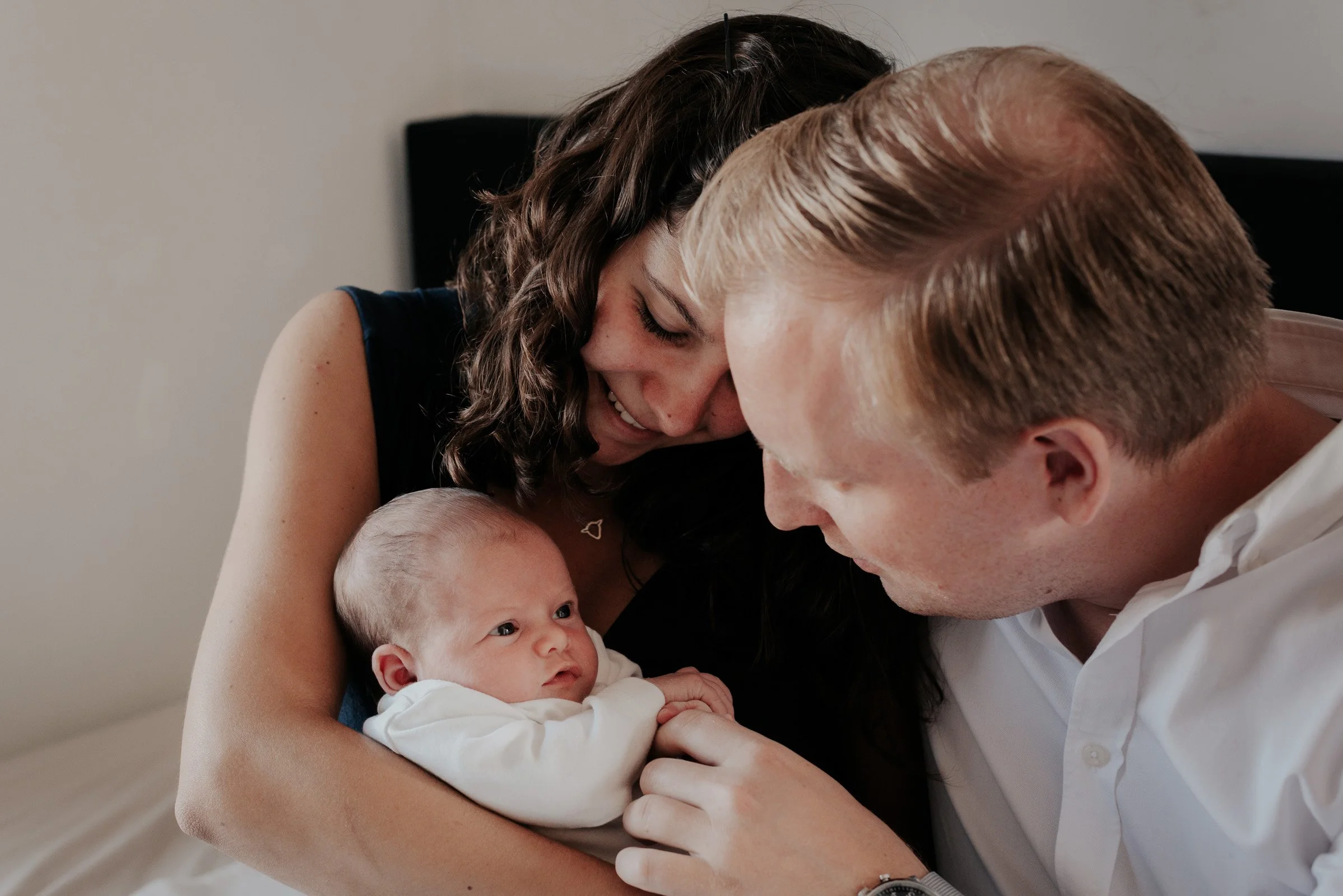 ouders bewonderen hun pasgeboren baby tijdens fotoreportage