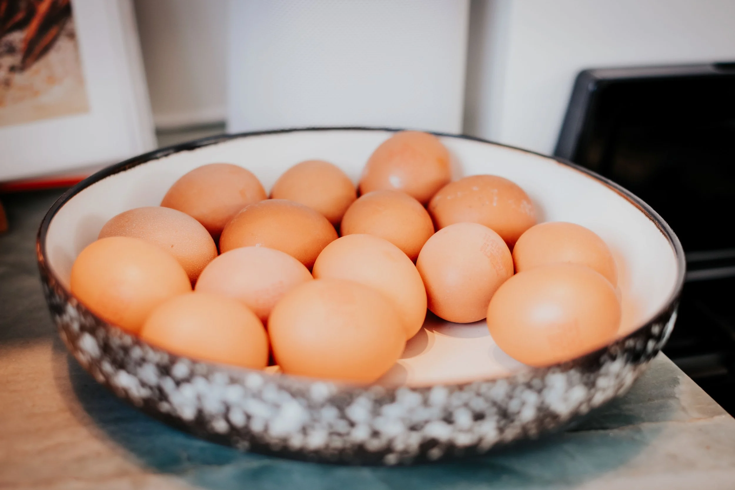 A bowl filled with brown eggs on a kitchen counter.