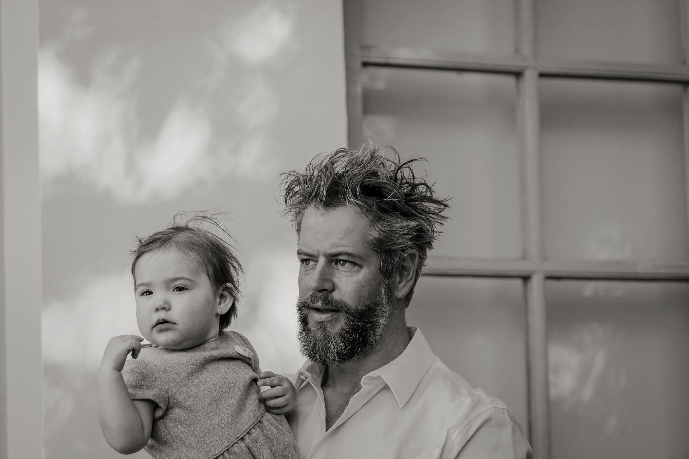 zwart-wit foto van peter met petekind tijdens fotoshoot op een feestje, waar kindje even rust nodig ahd