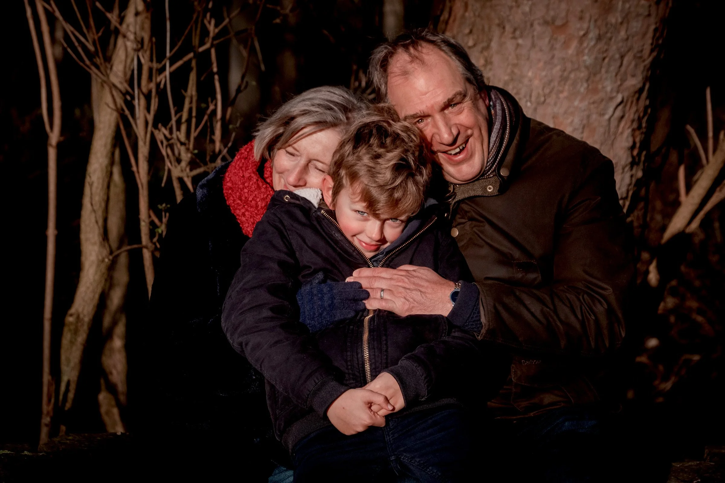 warme knuffel op een koude dag tussen grootouders en kleinzoon tijdens familie fotoshoot