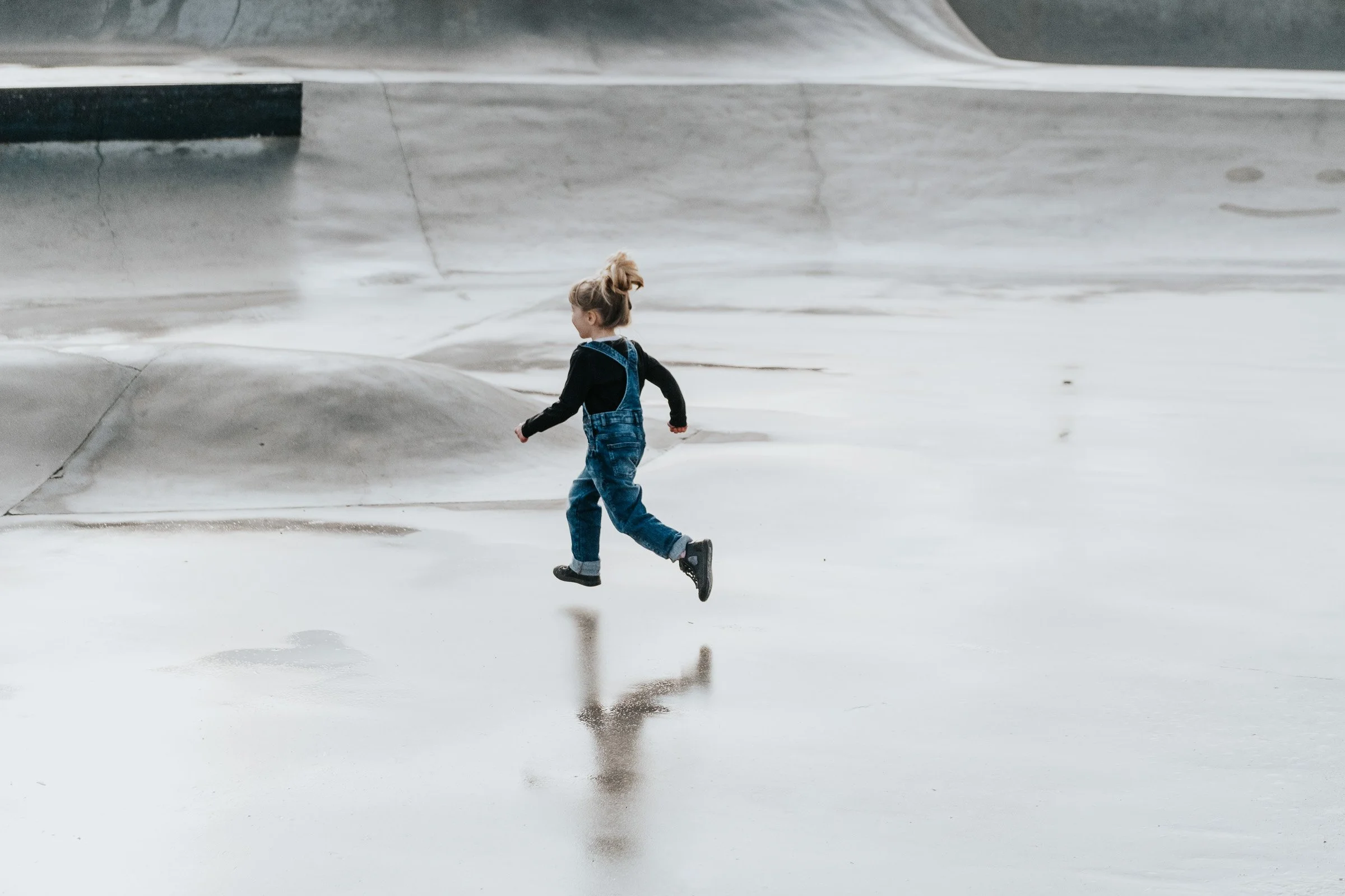 meisje geniet van het loven door de plassen op skatepark tijdens day-in-the-life fotoshoot