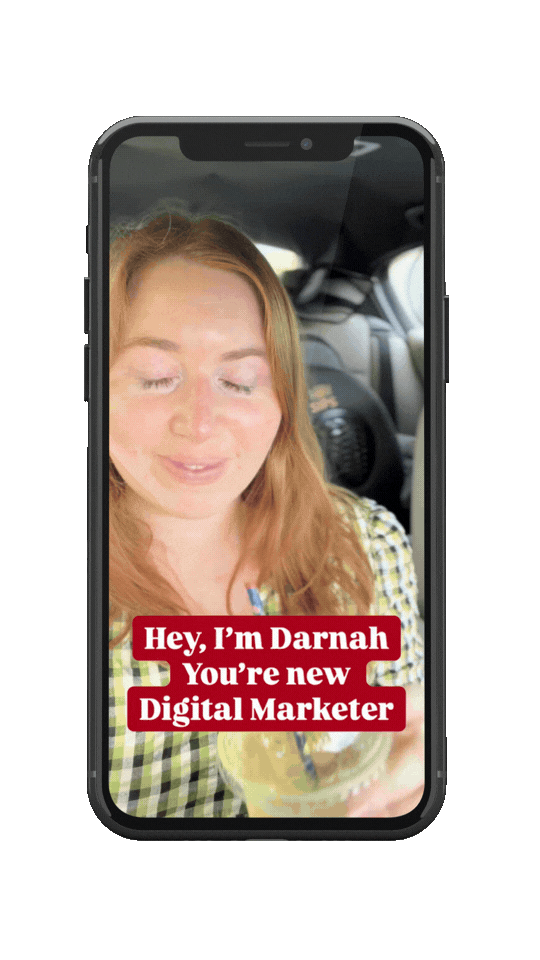 A woman with long red hair, wearing a green and white checkered shirt, holding a drink with a straw, sitting in a car. Text overlay: 'Hey, I'm Darnah. You're new Digital Marketer.'