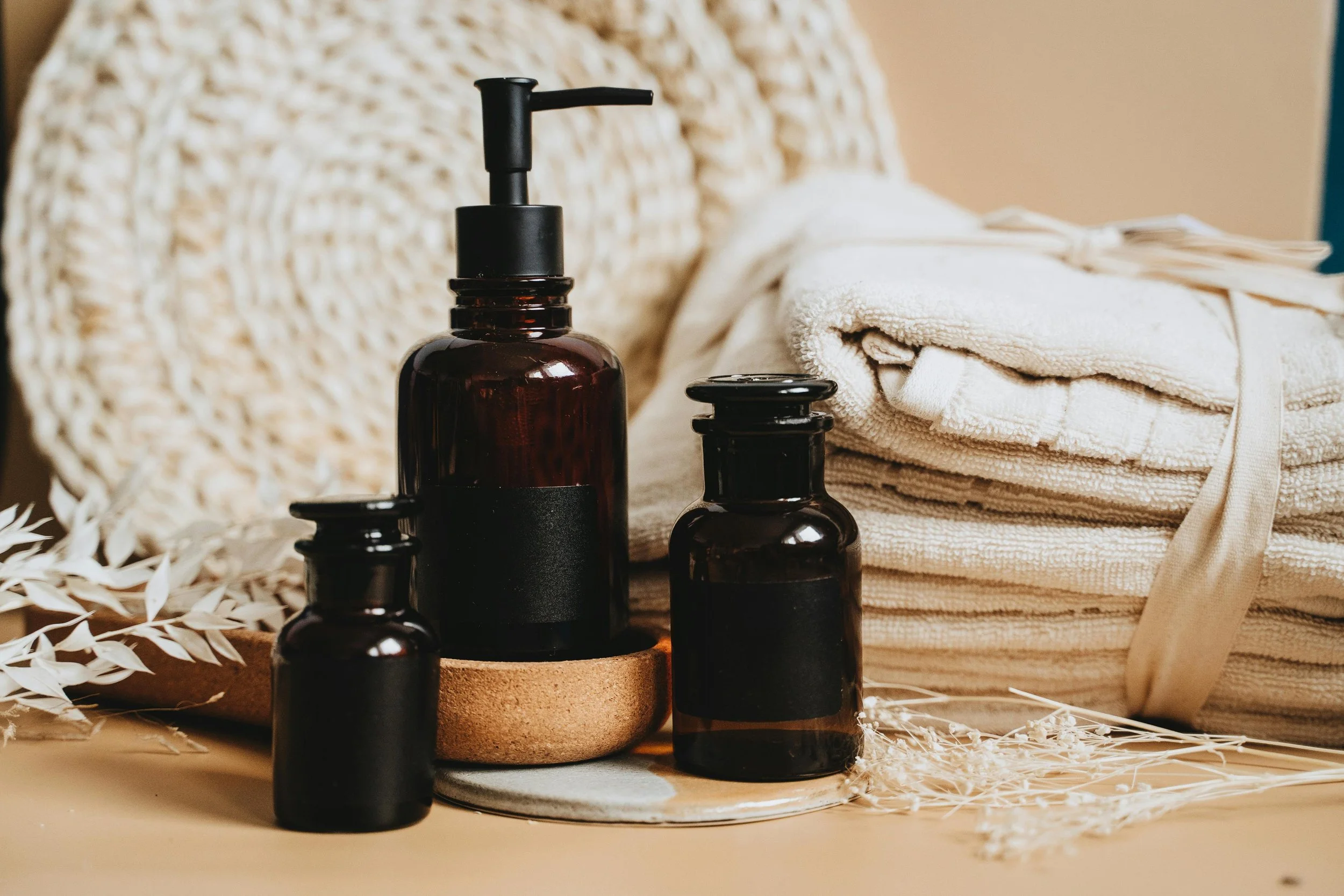 Natural wellness setting with towels, essential oils and calming spa elements at Byron Better Health.