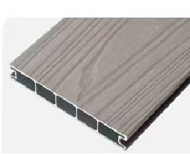Close-up of a gray composite deck board with a wood grain texture and a hollow core design.