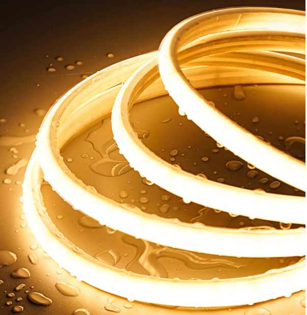 Close-up of three illuminated silicone rings with water droplets on a metallic surface.