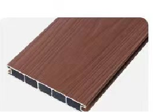 Close-up of a brown composite decking board showing wood grain texture and internal hollow support structure.