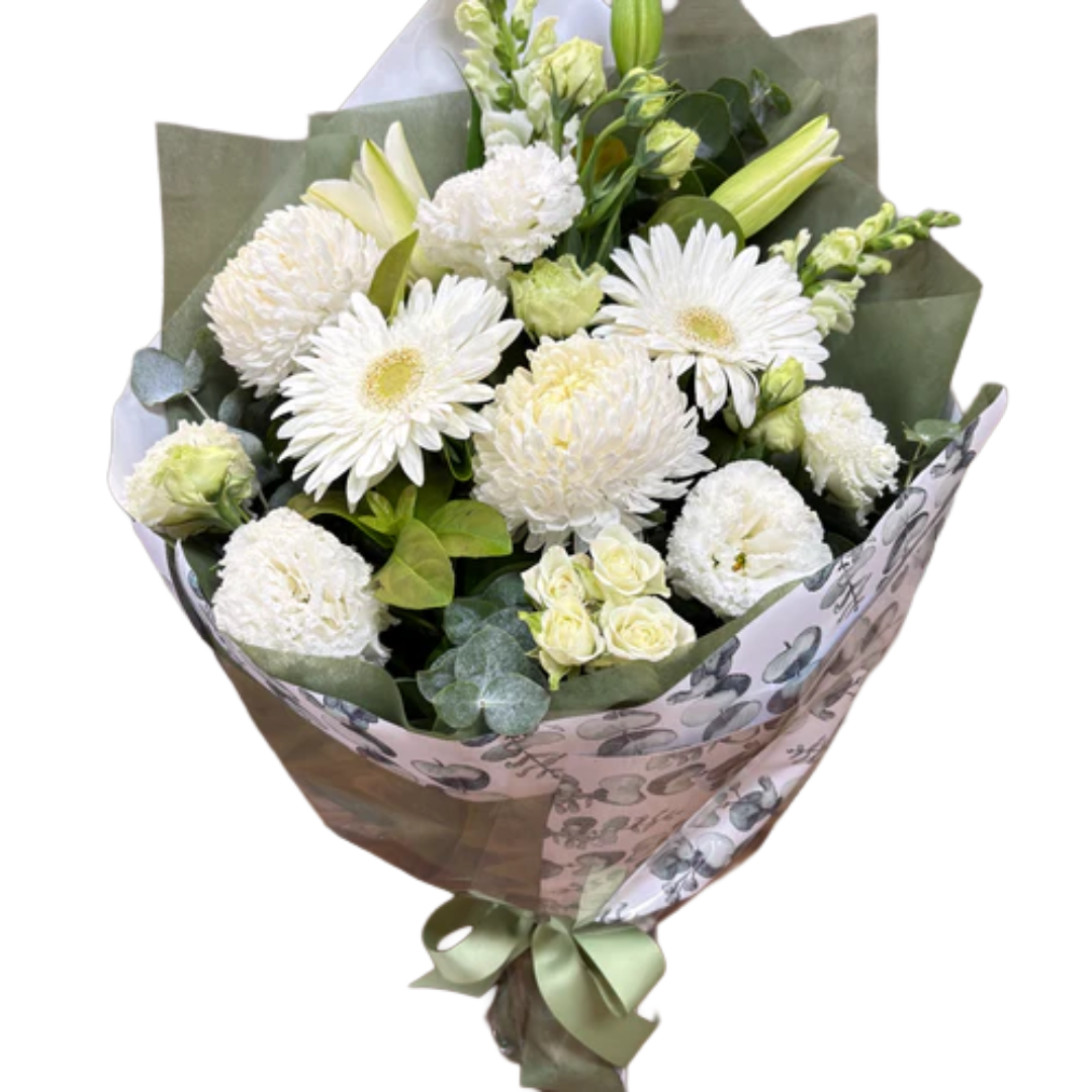 A bouquet of white flowers including gerbera daisies, carnations, roses, and lilies, wrapped in decorative paper with a satin ribbon.
