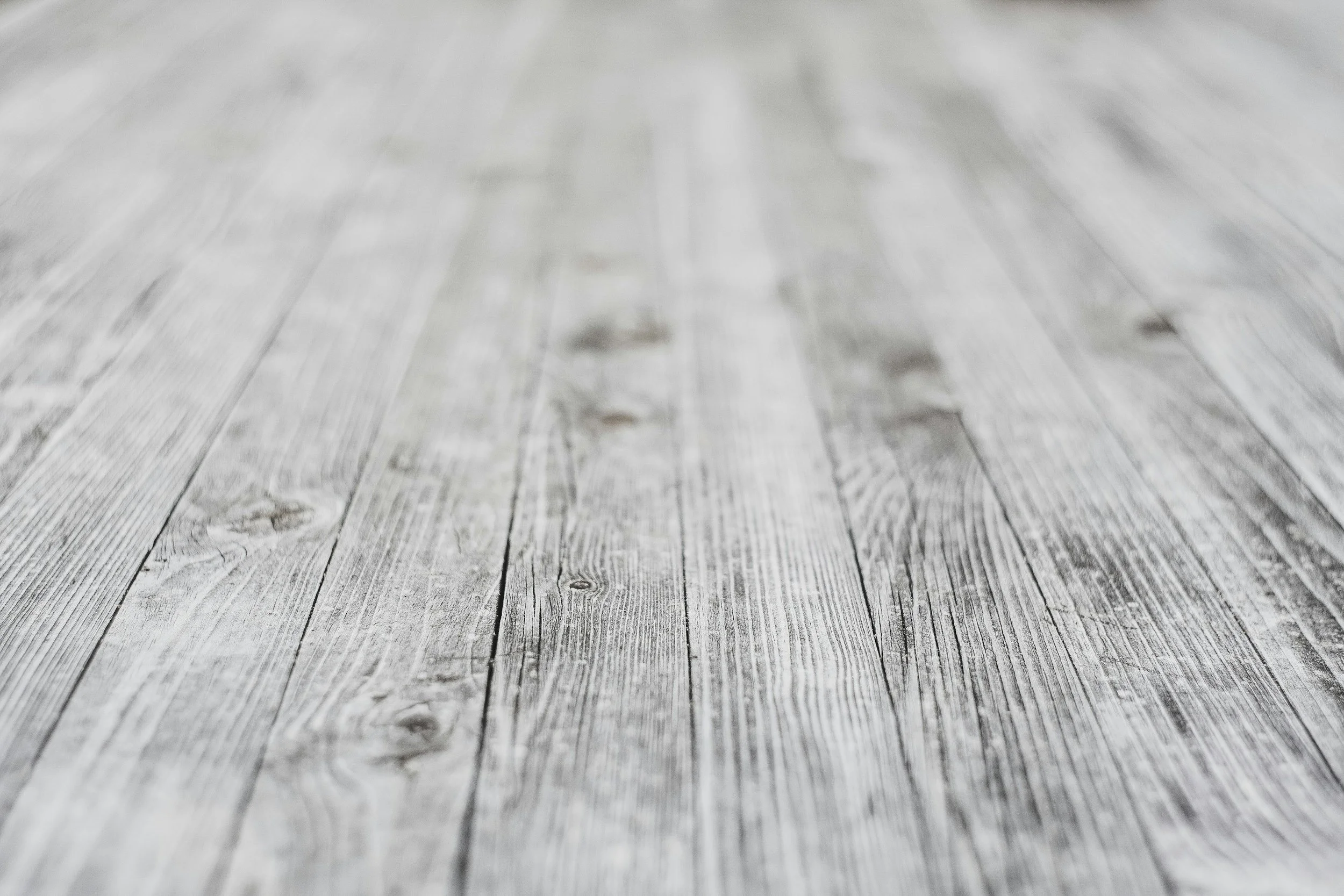 Close-up of weathered wooden floorboards with visible grain and knots.