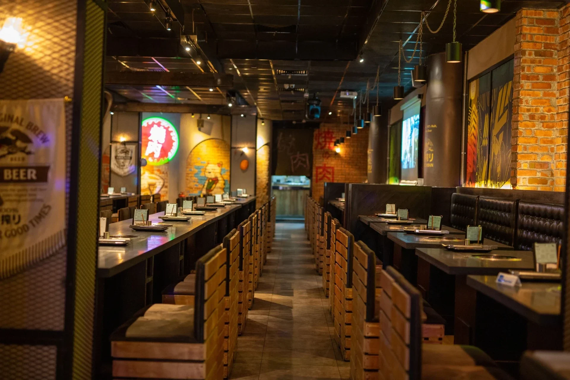 Interior of a Japanese restaurant with long counter seating and booth tables