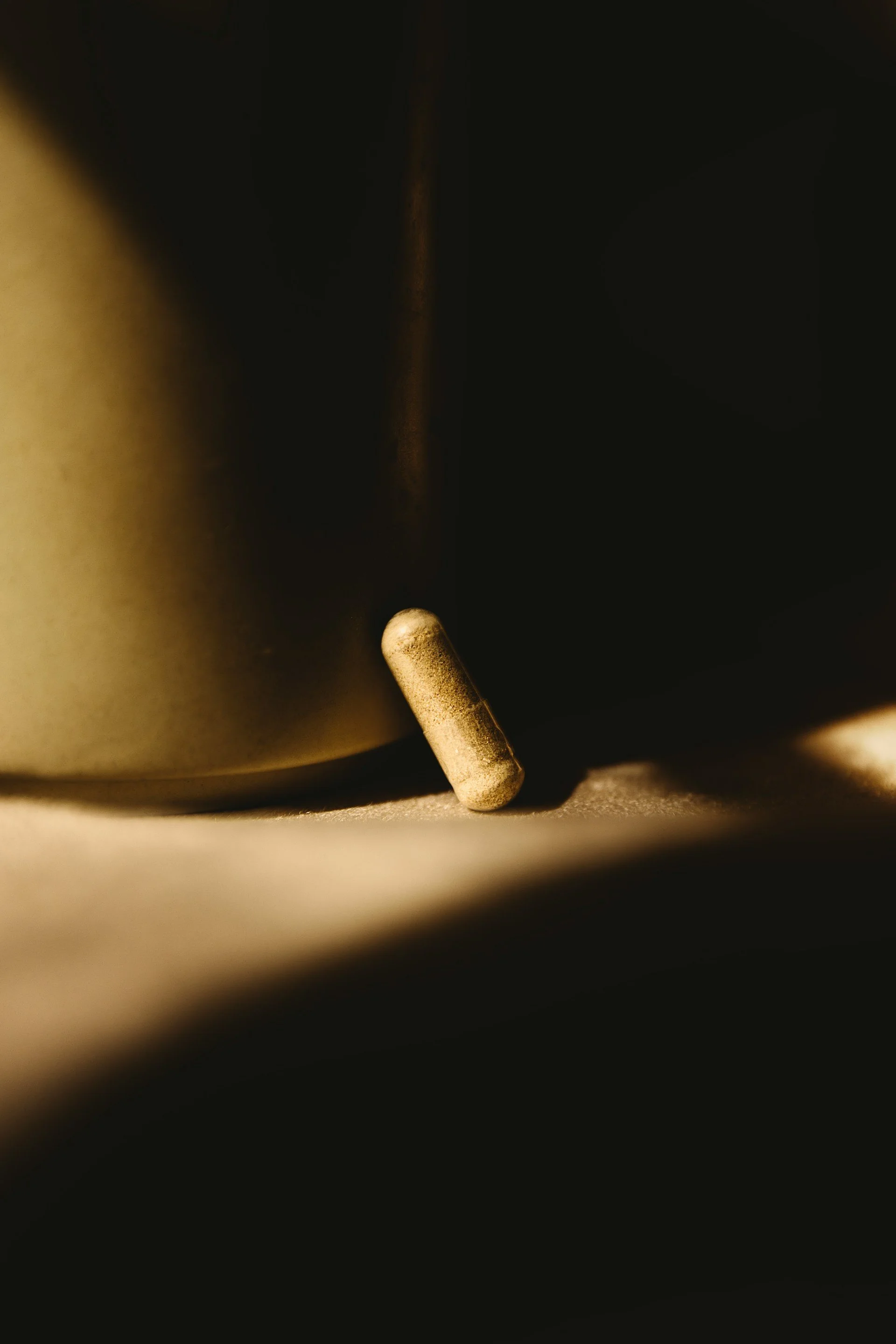 Close-up of a matchstick leaning against a black surface with a dark background.
