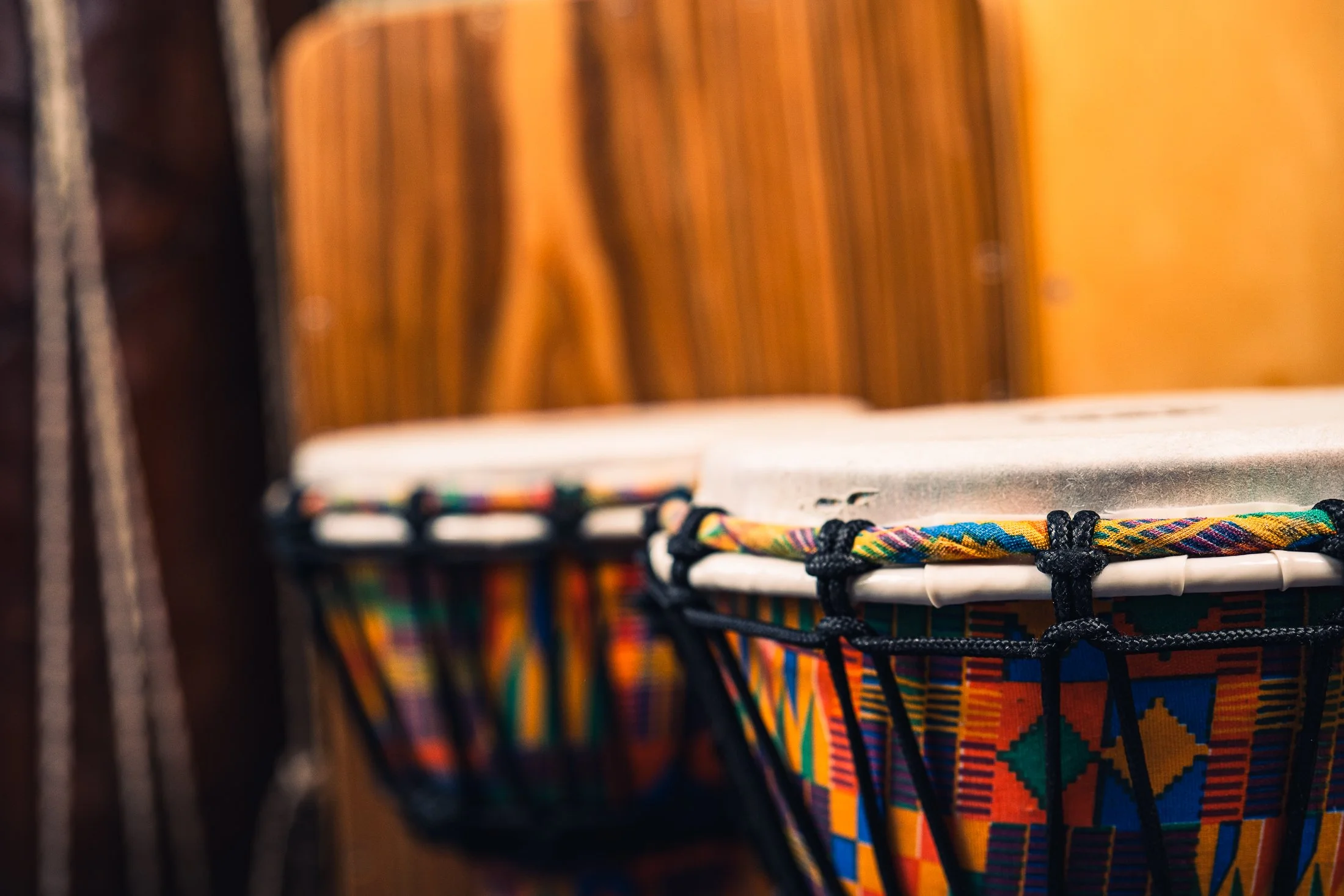 Colorful woven fabric wrapped around a white support bar in a shop or market setting.