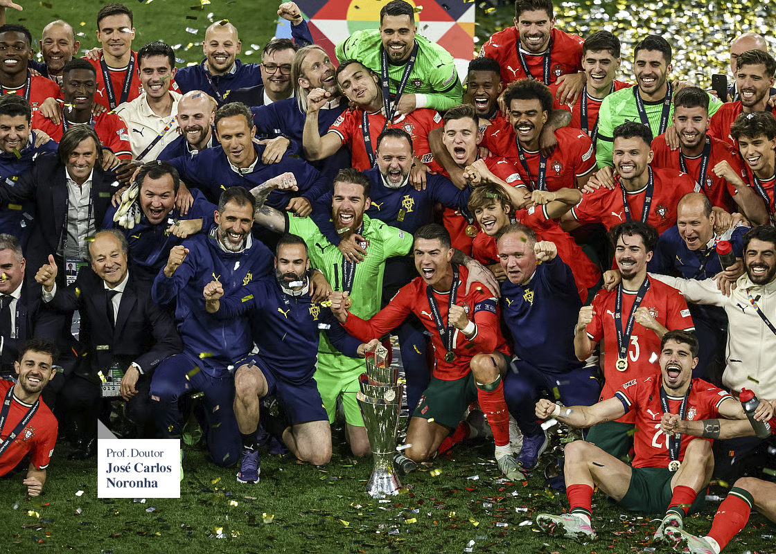 Seleção Portuguesa de Futebol. Foto de grupo de jogadores e comissão técnica de futebol comemorando uma vitória com troféu, roupas vermelhas, azuis e verdes, confete e pôr do sol ao fundo.