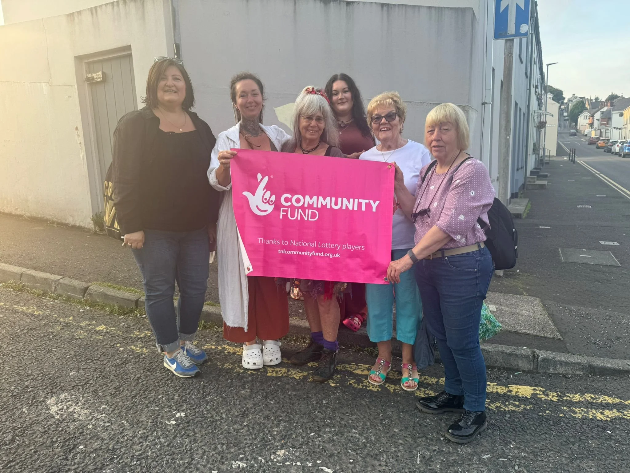 A community group holding a Community Lottery fund banner