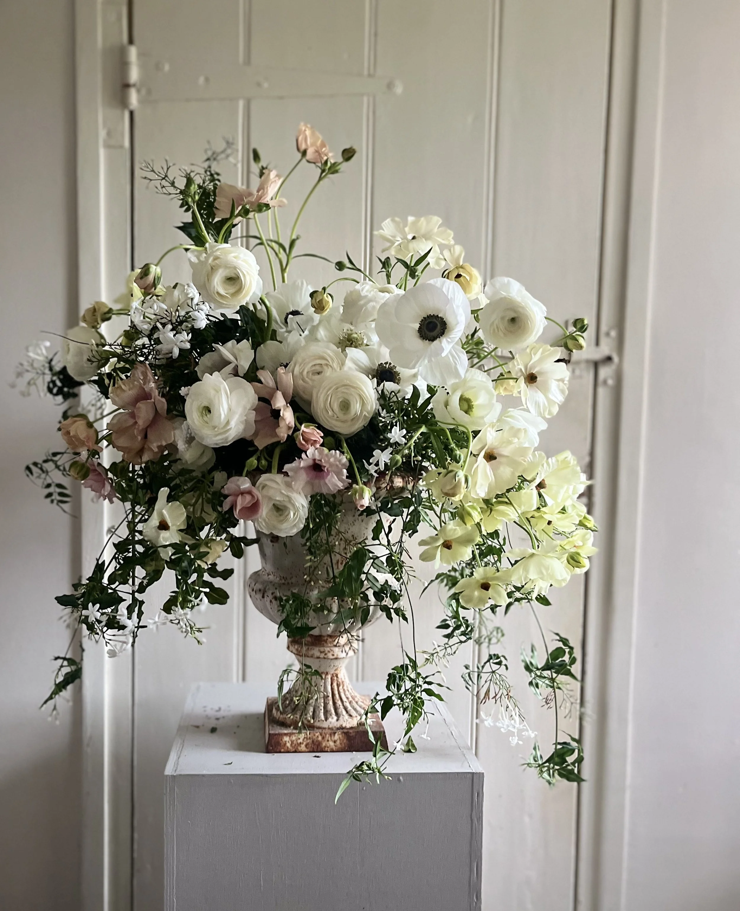 Spring urn with Ranunculus, anemone, jasmine and Iceland poppies. April wedding urn