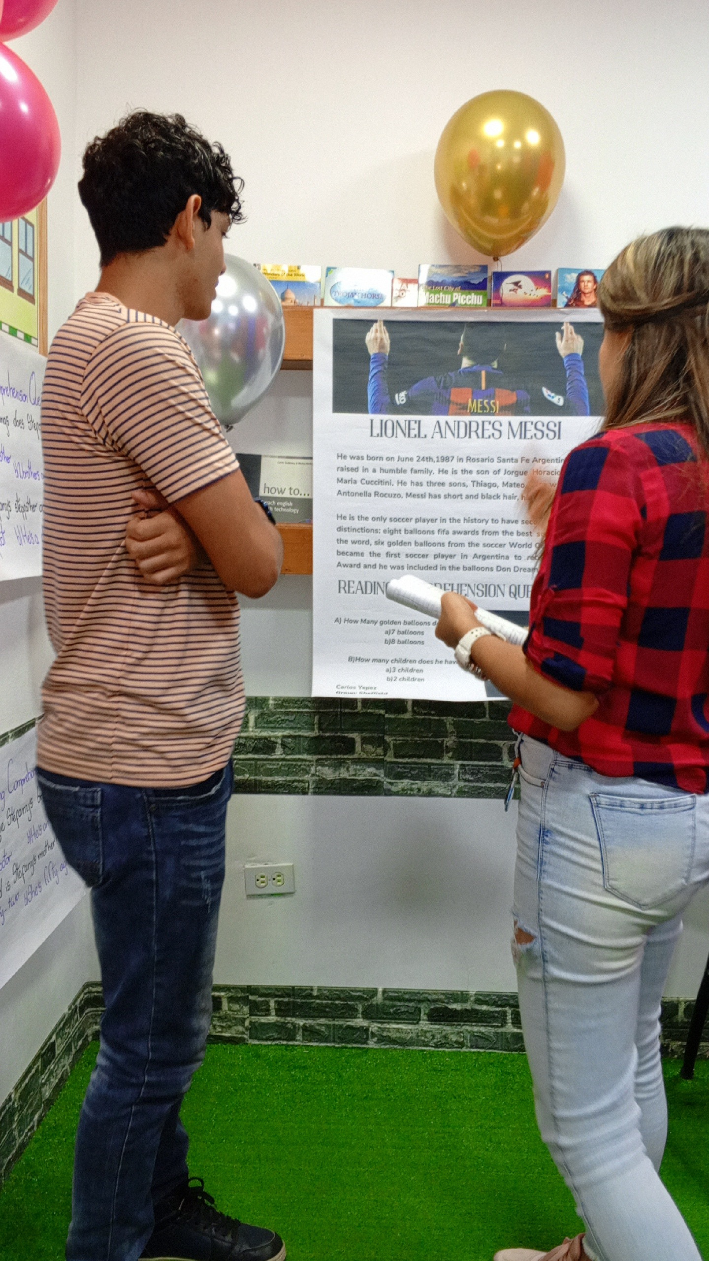 Dos personas observan un cartel sobre Lionel Andrés Messi en una exposición.