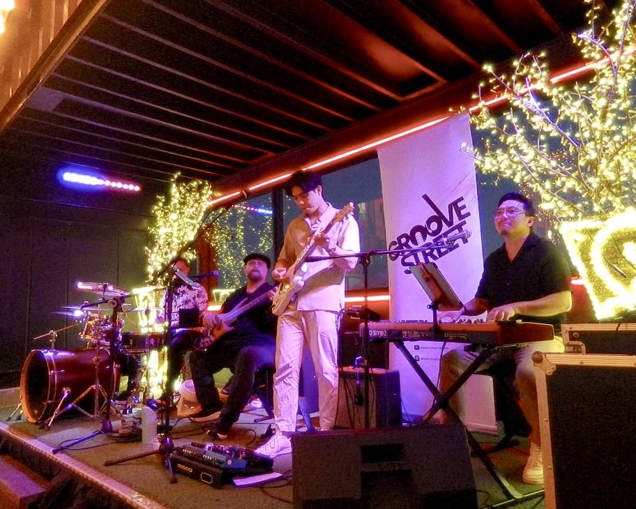 A jazz band performing on stage with stage lights and decorative string lights